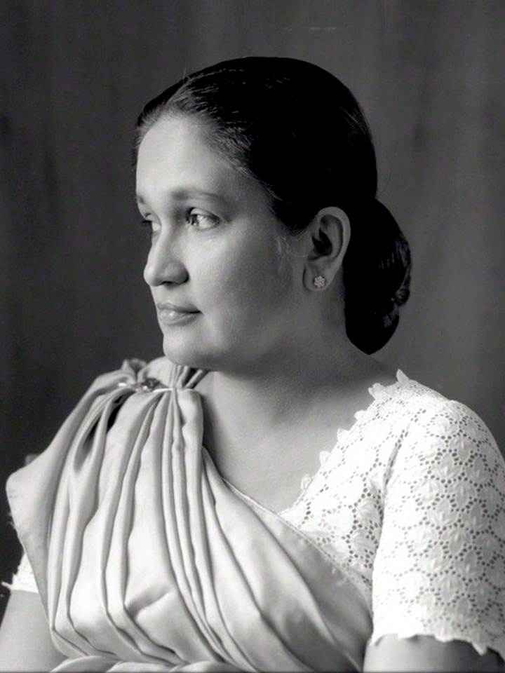 A black and white portrait of Sirimavo Bandaranaike, the world's first female prime minister. She is looking to the side, wearing a saree and an earring.