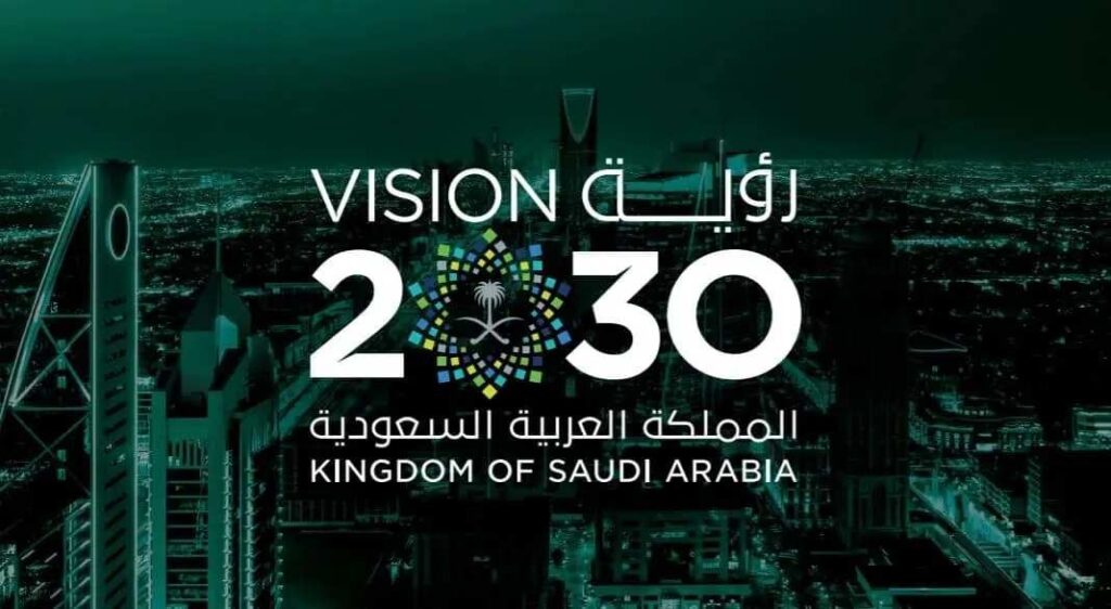  The logo for Saudi Vision 2030 is displayed against a dark, futuristic cityscape at night with green lighting. The text "VISION" is on the left in English, and "رؤية" in Arabic on the right. Below it, the number "2030" is prominent, with the '0' replaced by a circular emblem featuring a stylized palm tree and two crossed swords, which is the national emblem of Saudi Arabia, surrounded by a pattern of colorful squares. Below the number, "المملكة العربية السعودية" (Kingdom of Saudi Arabia) is written in both Arabic and English.